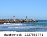 Small photo of Lighthouse on Wave breaker and Stone pier at sea. View of the mediterranean sea with the Lighthouses at rocky shore. Wave breakers along the shoreline with Lighthouse at ocean. Lighthouse on blue sky.