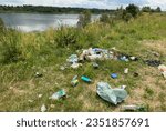 Small photo of People throw garbage near lake in nature. Trash at camping resort. Garbage dump in Illegal location. Pile of rubbish in nature. Environmental pollution and ecology. Illegal dumping of Garbage.