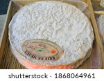 Small photo of PARIS, FRANCE -23 DEC 2019- View of a wheel of ripe Brie de Meaux cheese with a protected appellation label at a cheese market in Paris.