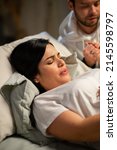 Small photo of Focused woman giving birth at home. Woman with pierced nose lying, feeling contractions during childbirth. Pregnancy, home birth concept