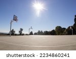Empty sunlit basketball court...