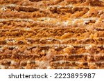 Small photo of Traditional honey cake. Close up of layered cake slice with honey base and white sour cream filling. Macro shot of cake cut as a textured background