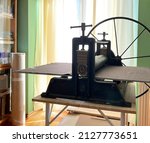 Small photo of Etching press for printmaking. Linocut, woodcut, etching, monotype, print, embossing stamp. Art equipment in studio. Old ancient engraving machine. Space for text. Art printing step process hand made