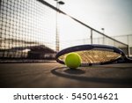 Tennis ball and racket on hard...