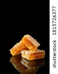 Small photo of Delicious fresh honeycombs on a black background with reflexion. Close up, side view, copy space for text Beekeeping, organic honey, healthy food