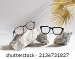 Clear Eyeglasses Glasses with plastic Frame Fashion Vintage Style on gray Background, trendy Still Life Style. Tortoiseshell frame glasses on stones. Optic store advertisement background
