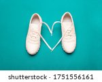 The concept of love for fitness. white sneakers with a heart, on a bright blue background. selective focus