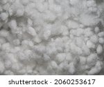 Synthetic fiber, white synthetic winterizer on a black background. Polyester fiber, siliconized holofiber. It is used as a filler for blankets, pillows, clothes and upholstered furniture. Close-up. 