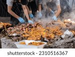 Small photo of A group of cooks set aside the meat and vegetables prepared underground as a part of the curanto ceremony. Colonia Suiza, Bariloche, Argentina.