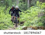 Cycling outdoor adventure. Two cyclists with enduro mtb bikes in forest in the Italian alps. Cycling e-mtb enduro trail track. Outdoor sport activity. At the lago di braies, Dolomites, Italy