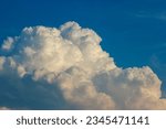 Small photo of A large white cloud in a blue sky. The cloud is fluffy and round, and it takes up most of the sky. The sky is a deep blue color, and it is clear except for the cloud.