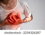 Small photo of Asian young man suffering from left sided chest pain. Chest pain can be caused by heart attack, myocardial infarct or ischemia, myocarditis, pneumonia, stress, etc.