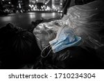 Small photo of monotone picture of a used medical mask toss away among garbage pile.