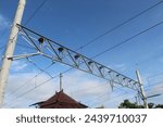 Small photo of Electric train trolley pole electrification system on railroad tracks with blue sky above