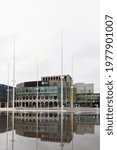 Small photo of Birmingham, West Midlands, UK - May 20th 2021: Birmingham Repertory Theatre in Centenary Square reflected in a water feature that contains fountains.