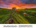 Small photo of Landscape in Scotland on the Isle of Skye in the evening. Summer sunset with Castle Ewen rock. sun star on the horizon. path on the cliff edge. Road with a small lake