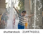 Small photo of Boys jumping in water fountains. Children playing with a city fountain on hot summer day. Happy friends having fun in fountain. Summer weather. Friendship, lifestyle and vacation.