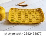 Small photo of Summer crochet big bag.Crochet market bag with wood crochet needle on white background. Handmade and craft. Summer big bag women, new trendy simple casual, large crochet shoulder bag.