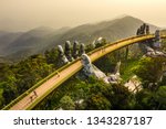 Top aerial view of the famous Golden Bridge is lifted by two giant hands in the tourist resort on Ba Na Hill in Da Nang, Vietnam. 