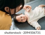 Small photo of Young mother is coaxing a newborn baby to sleep