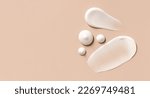 Small photo of cosmetic smears of creamy texture on a beige background
