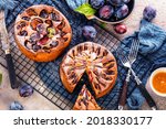Small photo of rustic plum cake on dark background , top view