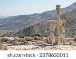 Small photo of Triumphal arch and honorary column at Upper Agora in ancient city of Sagalassos. Scenic mountains of Pisidia at background. Aglasun, Budur, Turkey