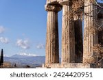 Small photo of Doric colonnade Temple of Apollo in Ancient Corinth close up, with beautiful mountains and Peloponnessian landscape at background. Corinth, Greece
