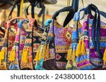 Small photo of Turkish handwoven bags flaunt vibrant patterns and tassels, ethnic flair. Souvenirs or gifts displayed at street bazaar store.