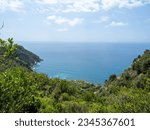 Corniglia, Italy -  July 03 2023: Cinque Terre National Park seen from the hiking trail. The Cinque Terre comprises five villages: Monterosso al Mare, Vernazza, Corniglia, Manarola, and Riomaggiore.