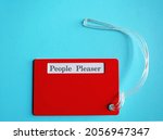 Small photo of Red card on blue background with words PEOPLE PLEASER, means people who put someone else needs ahead of their own, overly concerned with pleasing ,doing whatever it takes to make other people happy