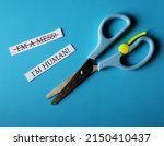 Small photo of Scissors on blue background with handwritten two paper notes I AM A MESS, changed to I AM HUMAN - to overcome negative self talk or inner voice critic, change to positive thought to boost self esteem