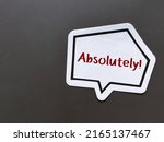 Small photo of Speech sticker on copy space gray background with handwritten text ABSOLUTELY! means to agree completely - beyond any doubt , totally certain or very clear explanation or without exception