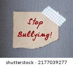 Small photo of Torn brown paper stick on wallpaper background with handwritten text STOP BULLYING, concept of stop hurting or frightening someone else by degrade or demean victims just to feel powerful or stronger