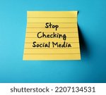 Small photo of On blue background, handwritten stick note STOP CHECKING SOCIAL MEDIA, decision making to limit or stay away from social media to overcome addiction, gain more time, less distracted and less stressed