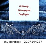 Small photo of Note in jean pocket with handwritten text Actively Disengaged Employee - refers to employees who are unhappy at work and busy undermining workplace by getting others to share in their discontent