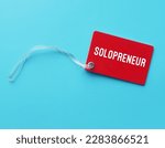 Red tag card on blue background with text written SOLOPRENEUR, person who sets up and runs business on their own, works independently and doesn't hire employees