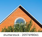 blue sky over brick gable wall with window of house on sunny day