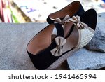 Stock photo of beautiful pair of black and cream color high heel sandals displayed on blur background ,kept on table under bright sunlight at Bangalore city Karnataka India.
