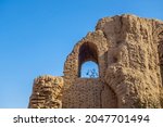 Small photo of Part of a collapsed wall and a window opening overlooking the clear blue sky. Medieval architectural monument of the 9th century - the palace or caravanserai Kyr Kyz in Termez, Uzbekistan