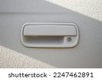Door handle on a white car door coated with a 2-component heavy-duty protective paint for extreme conditions, raptor paint.