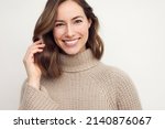 Portrait of a happy smiling brunette woman looking beautiful standing isolated on white background in a sweater. Young female girl with a perfect smile.
