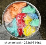 Small photo of Baby's colorful clothes soaked in soak in powder detergent water dissolution on the cement floor .laundry concept dry and cleaning care for clothes