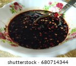 Small photo of Hot chilied soy sauce in a small white bowl. Delicious addon to add spiciness in the food. Visible flower pattern on the bowl