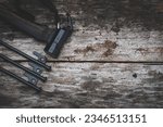 Small photo of Tent peg nail iron hammer handle is made of ebony wood on old wooden background
