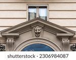 Small photo of Turin, Piedmont, Italy - 12 24 2022: Detail of the entrance of an old palace with a tympanum decorated with the head of a demon