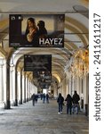 Small photo of Turin, Piedmont, Italy - 12 09 2023: Arcades of Piazza San Carlo with billboards of the Francesco Hayez exhibition at the Turin Civic Gallery of Modern and Contemporary Art (GAM) and people walking