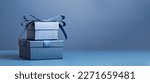 Small photo of Two Luxury gift boxes with a blue bow on dark blue. Side view monochrome . Fathers day or Valentines day gift for him. Corporate gift concept or birthday party. Festive sale copy space banner