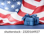 Blue Gift box against US American flag. Happy Independence Day. Stars and stripes. Copy space. memorial day