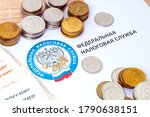 Small photo of Moscow, Russia December 12 2019, Emblem of the tax Inspectorate of the Russian Federation against the background of Russian cash, tax collection, tax rate increase